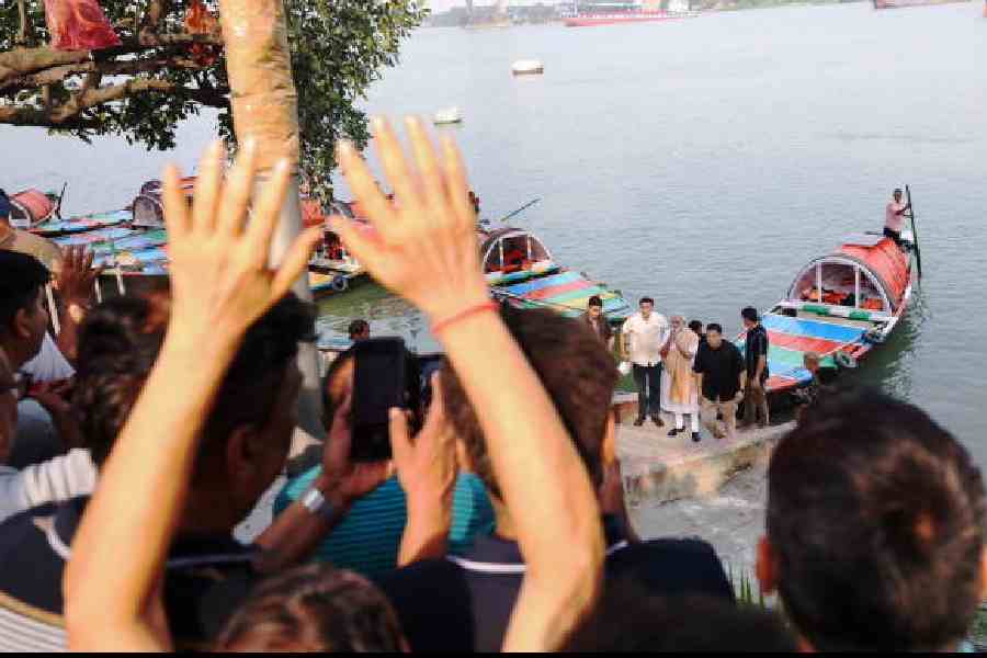 Prime Minister Narendra Modi greets the gathering on the banks of the Hooghly on Friday. (@narendramodi/X via PTI)
