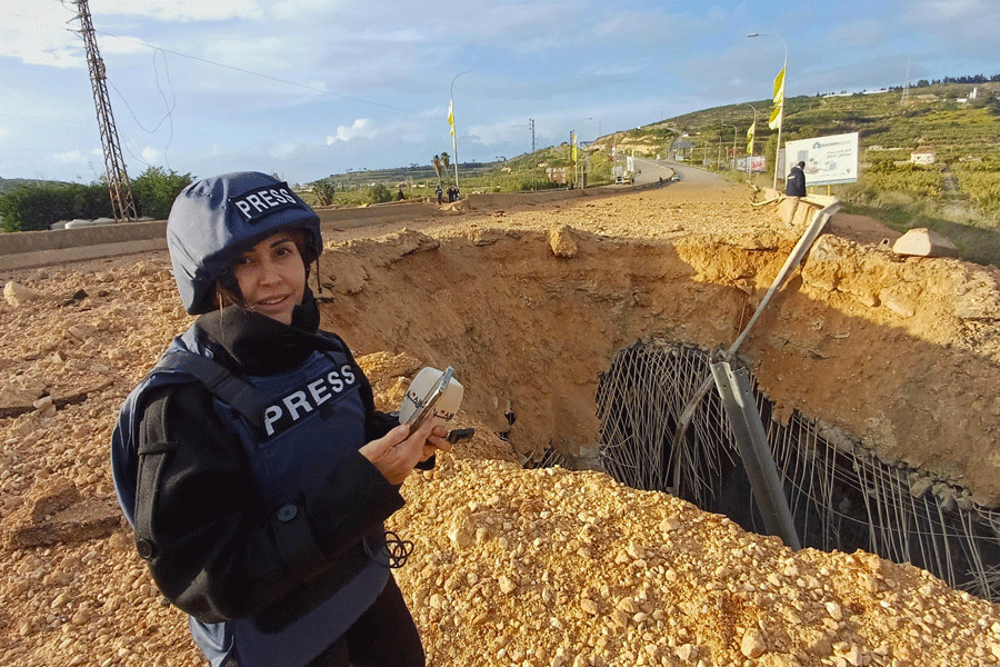 Lebanese journalist Amal Khalil, who works for the daily Al-Akhbar newspaper, reports near a destroyed bridge in Qasmiyeh, Lebanon, Sunday, March 22, 2026.