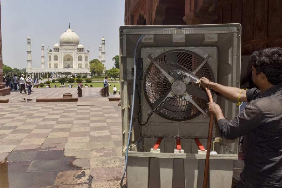 A worker cleans an air cooler amid summer heat, at Taj Mahal in Agra, Sunday, April 26, 2026.