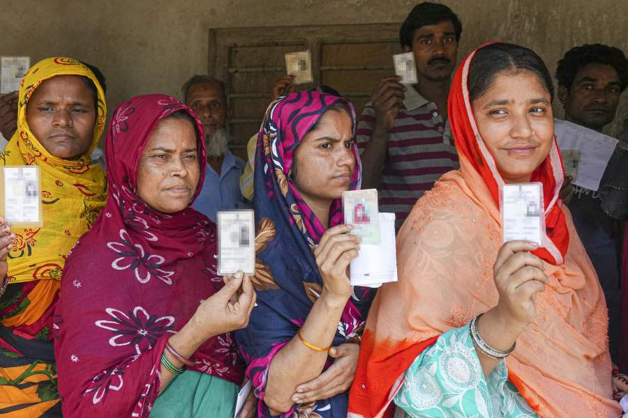 Women wait in a queue before voting in the first phase of the West Bengal Assembly elections, at a polling station in Panskura, Purba Medinipur, Thursday, April 23, 2026.
