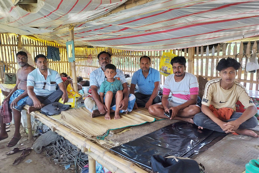 Villagers gather inside a temporary shelter as they wait together during the day.