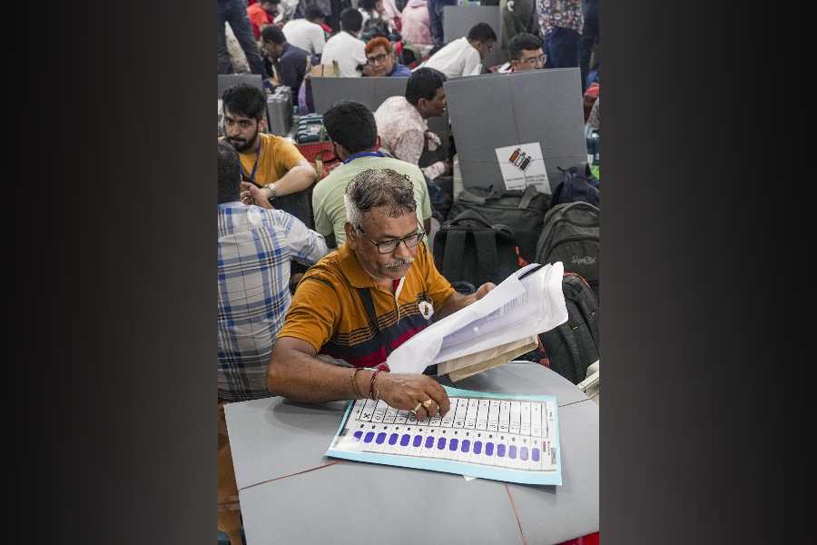A polling official checks election materials for voting in the second phase of the West Bengal Assembly elections, at a distribution centre in Kolkata, Tuesday, April 28, 2026.