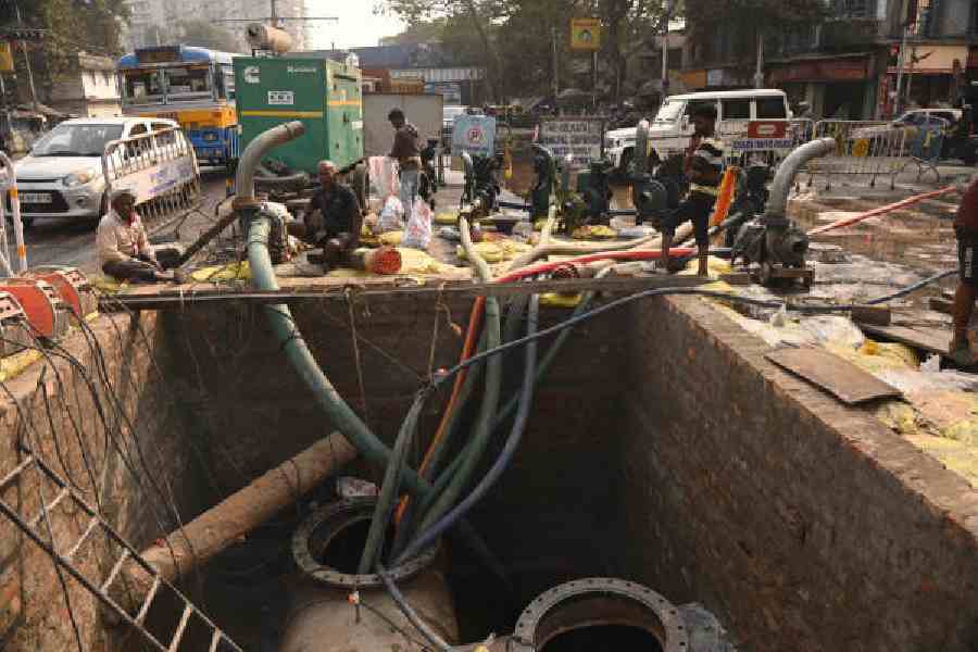 Workers lay a pipeline under SP Mukherjee Road, in Rashbehari and (right) Mudiali, on Saturday. (Bishwarup Dutta)