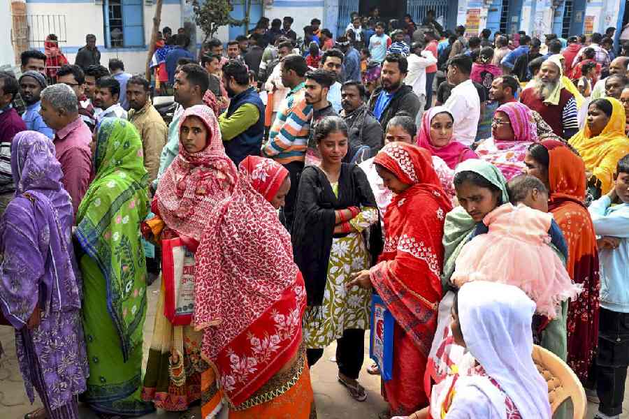 People wait outside a camp during hearings under the special intensive revision of electoral rolls in Malda on Monday.