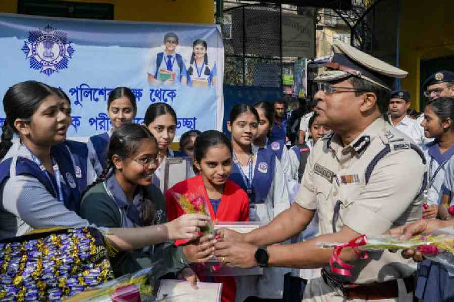 Kolkata Police commissioner Supratim Sarkar greets students outside an exam venue before they appear for Madhyamik on Monday. (PTI picture)