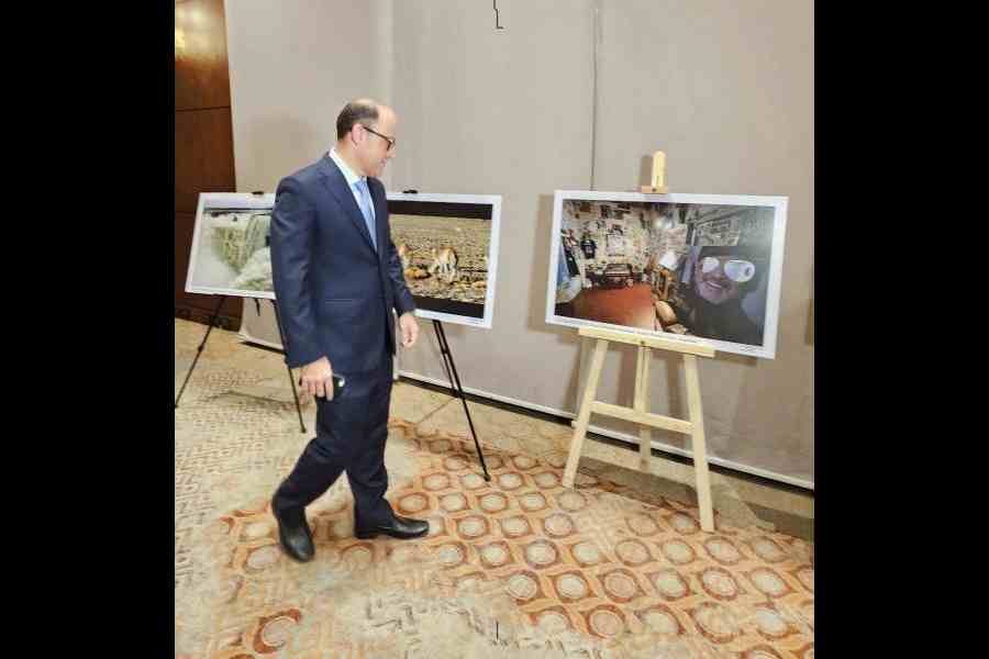 Ambassador Mariano Agusto Caucino looks at a picture of Diego Maradona's house at an exhibition on the sidelines of the reception at Hyatt Regency