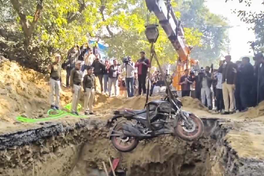 The bike being lifted out of the pit at Janakpuri in New Delhi on Friday. 