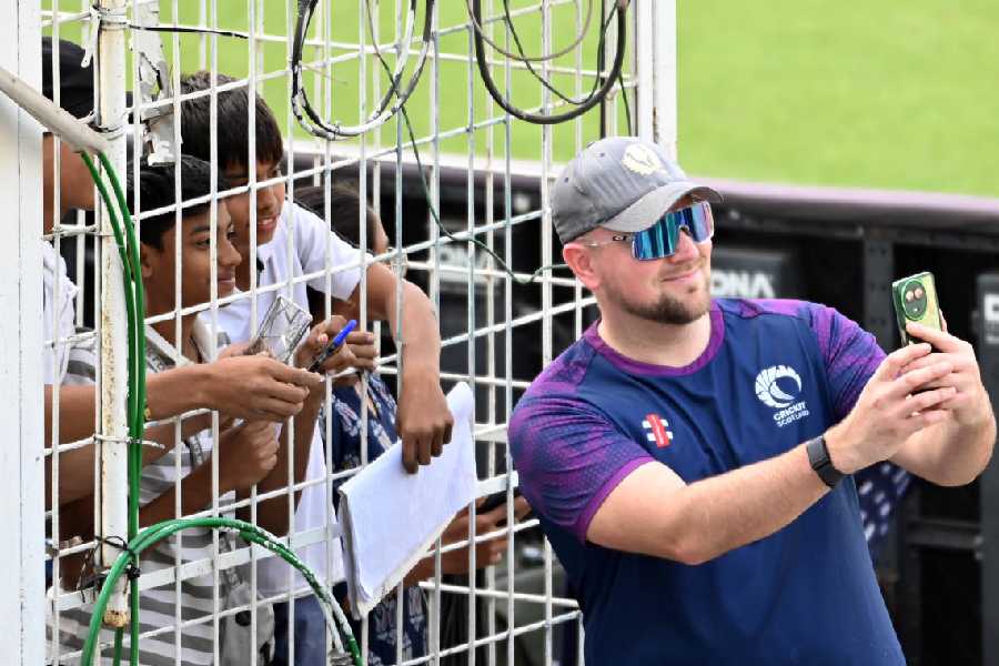 Scotland’s Mark Watt clicks a selfie with young visitors at Eden Gardens on Friday, ahead of Saturday’s game.