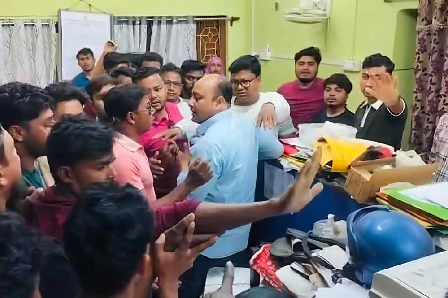 Alleged Trinamool Congress supporters heckle AERO Sanjoy Debnath (in blue shirt) inside the Baduria block development office on Saturday morning.