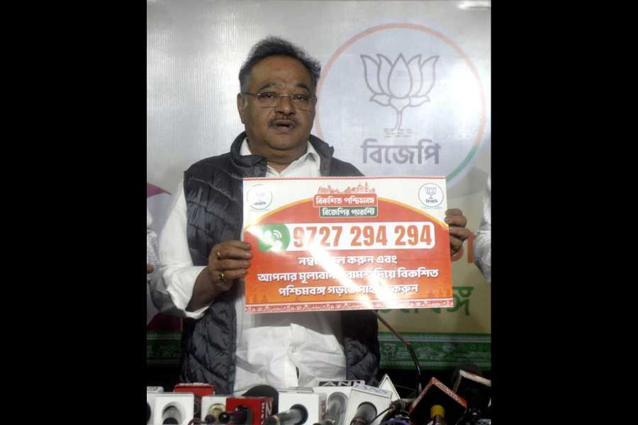 Samik Bhattacharya displays the toll-free number where people can give their suggestions for the BJP's Sankalpa Patra or election manifesto