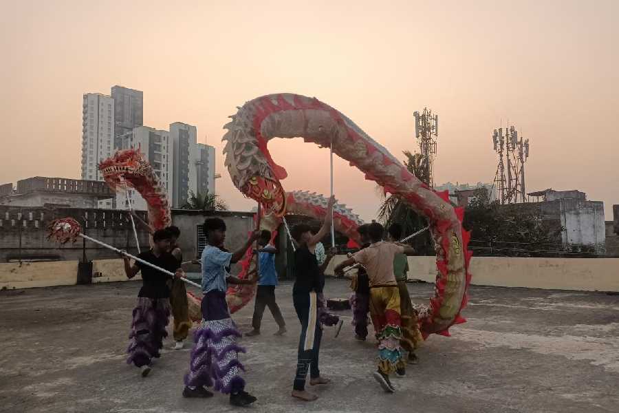 Teenage boys perform the snake dance on the terrace of Liao’s studio.