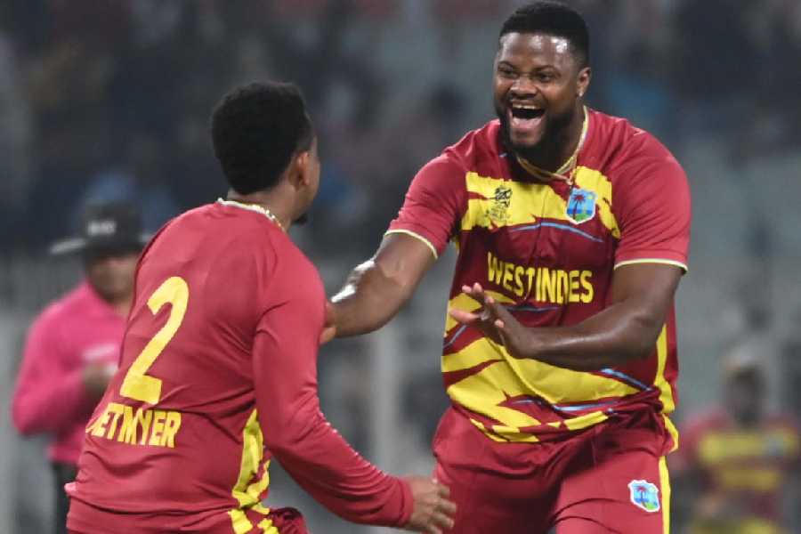 Romario Shepherd celebrates with Shimron Hetmyer (left) after completing his hat-trick, during theWorld Cup match against Scotland at Eden Gardens on Saturday.