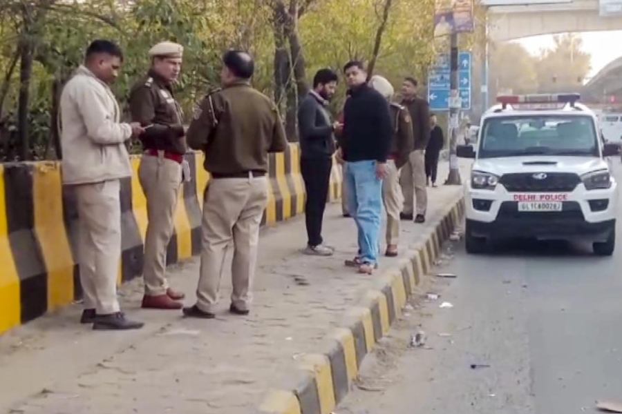 Police personnel investigate the spot after three people, including a woman, were found dead inside an abandoned car on the Peeragarhi flyover, in New Delhi, Sunday, Feb. 8, 2026.