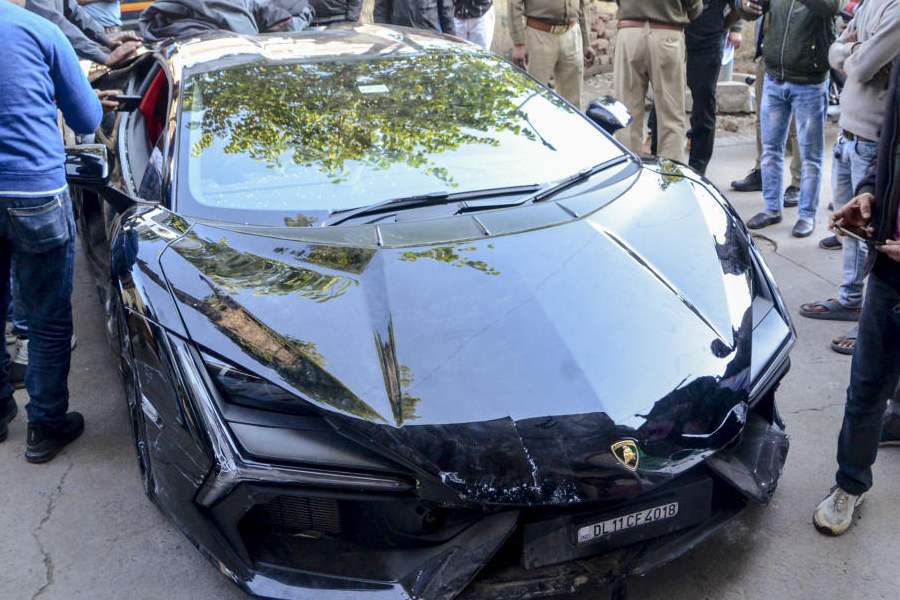 People gather around a Lamborghini car which collided with a rickshaw, injuring three people, in Kanpur, Sunday, Feb. 8, 2026.