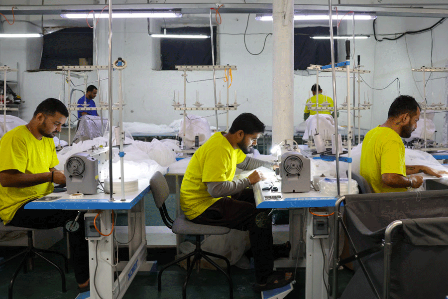 Migrant workers from India sew tulle fabric at a textile factory in Balashikha
