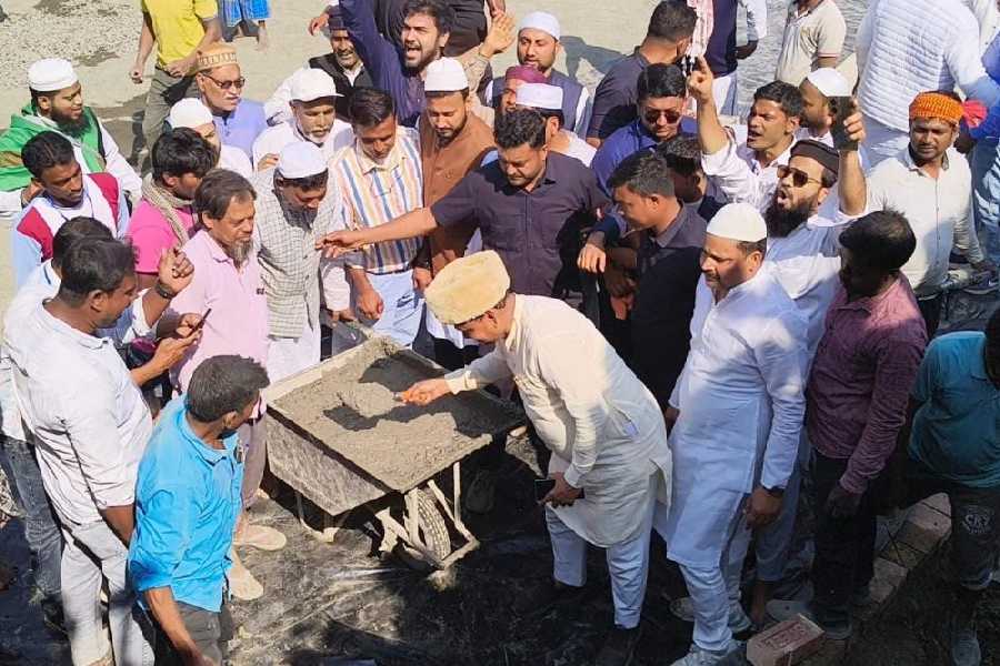 Humayun Kabir lifts a trowel with cement to start the construction of the mosque.