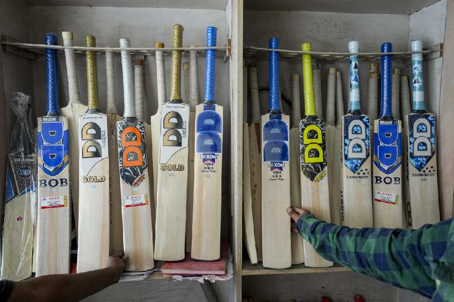 A worker selects pieces of wood for crafting cricket bats at a workshop, ahead of the ICC Men's T20 World Cup 2026, in Jalandhar