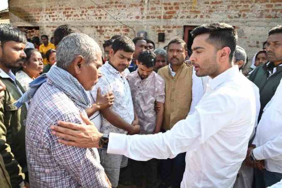 Abhishek Banerjee consoles a family member of deceased migrant worker Sukhen Mahato at Barabazaar in Purulia on Friday. Picture by Biswanath Roy