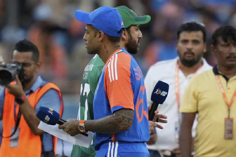 Pakistan's captain Salman Agha, rear, walks past India's captain Suryakumar Yadav