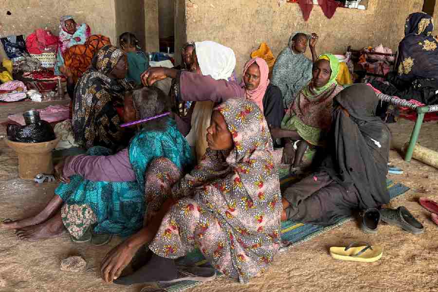 A displaced woman from Dalanj braids her grandmother's hair at a displacement registration center in El Obeid, North Kordofan State, Sudan, January 15, 2026.