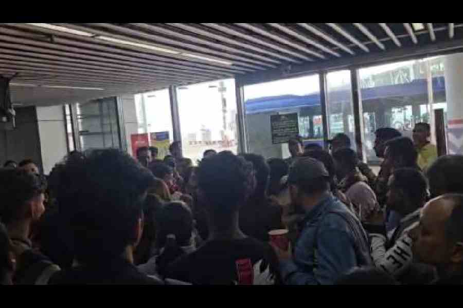 SpiceJet passengers to Mumbai wait near Gate no 101 of the Calcutta airport on Sunday