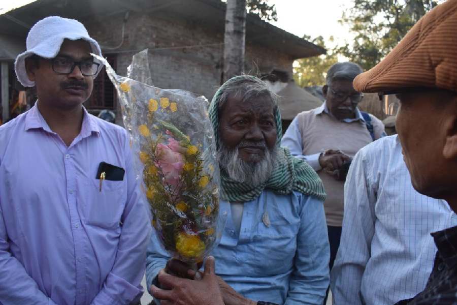 Amir Chand Sekh (wearing a white cap) and his father Abul Sekh being felicitated by a member of the science organisation at his home in Senpara near Krishnanagar on Sunday afternoon.