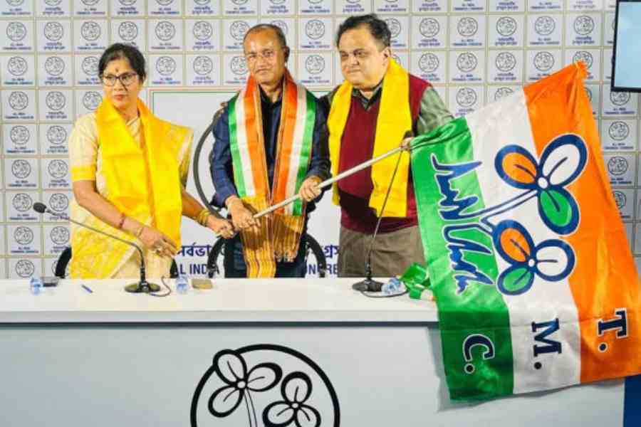Ministers Shashi Panja and Bratya Basu hand over the Trinamool Congress flag to Kurseong MLA BP Sharma (Bajgain) in Calcutta on Thursday