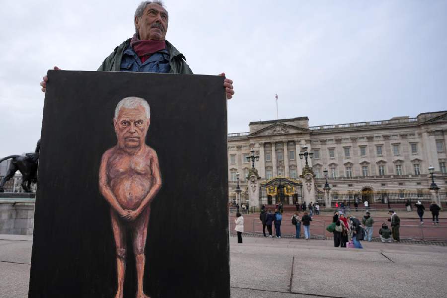 Artist Kaya Mar poses with the newest edition of his paintings for the media in front of Buckingham Palace, London