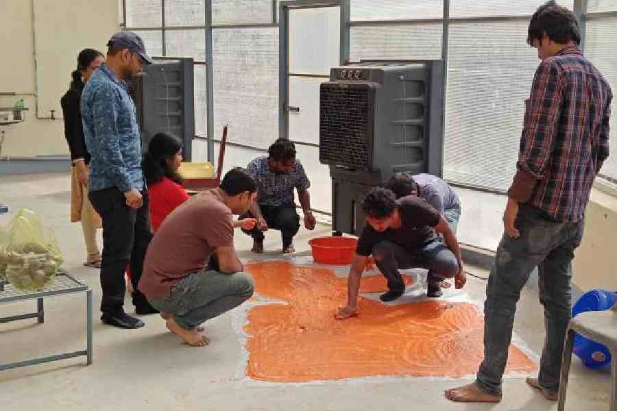 Kalyani University students spread out the herbal abir mixture on a flat surface to dry