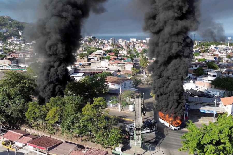 Smoke billows from burning vehicles amid a wave of violence, with torched vehicles and gunmen blocking highways in more than half a dozen states, following a military operation in which a government source said Mexican drug lord Nemesio Oseguera, known as "El Mencho," was killed, in Puerto Vallarta, Jalisco, Mexico