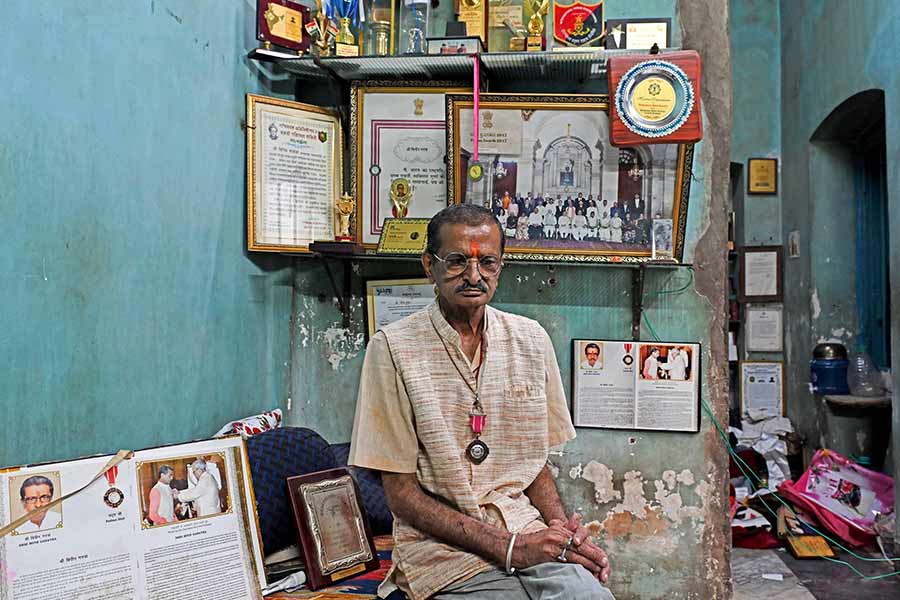 Bipin Ganatra lives in a cramped one-room accommodation , surrounded by old certificates and a Padma Shri medal