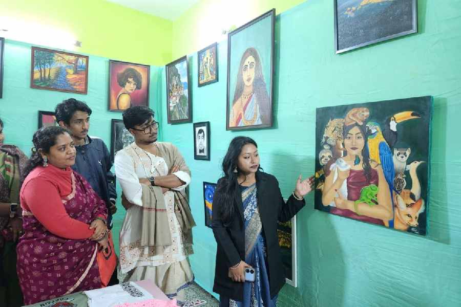 A painter shows her work to others at Surekha art school