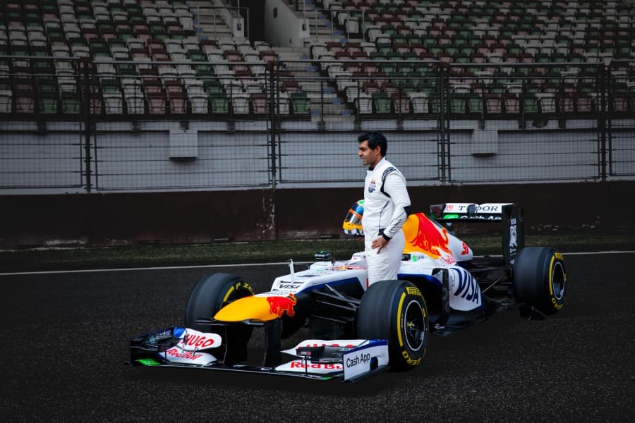 Karun Chandok standing in front of the Red Bull Racing RB8