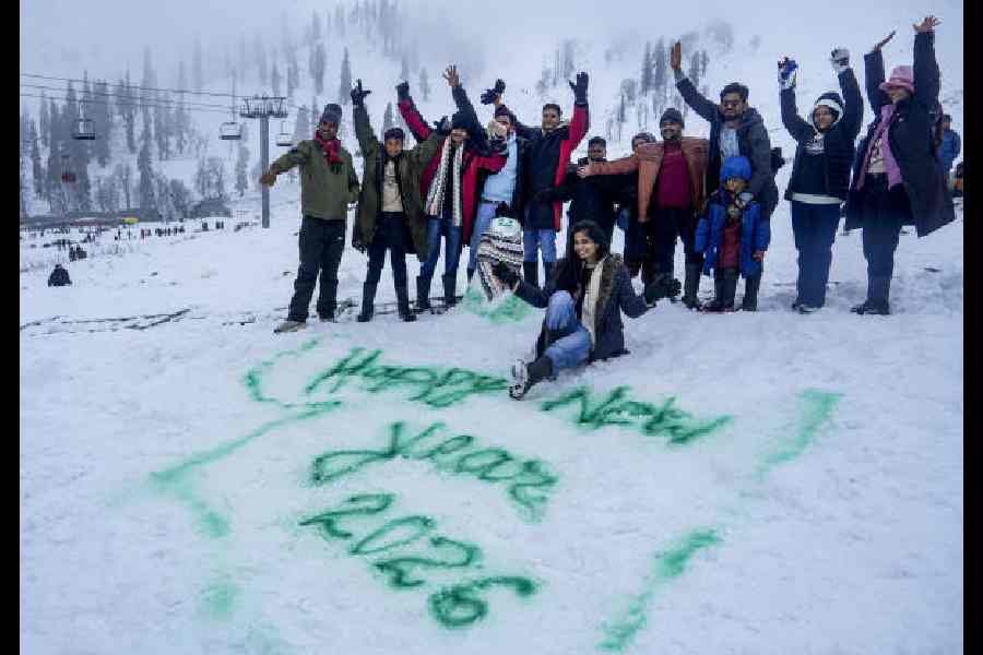 Tourists enjoy snowfall in Gulmarg on Wednesday. 