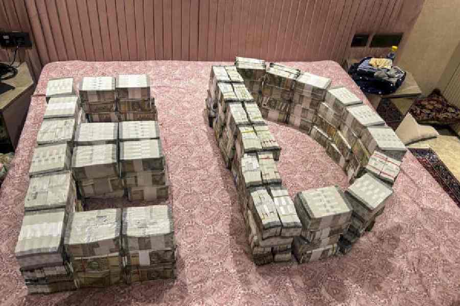 ED officials display cash seized during the raid in New Delhi on Wednesday. 