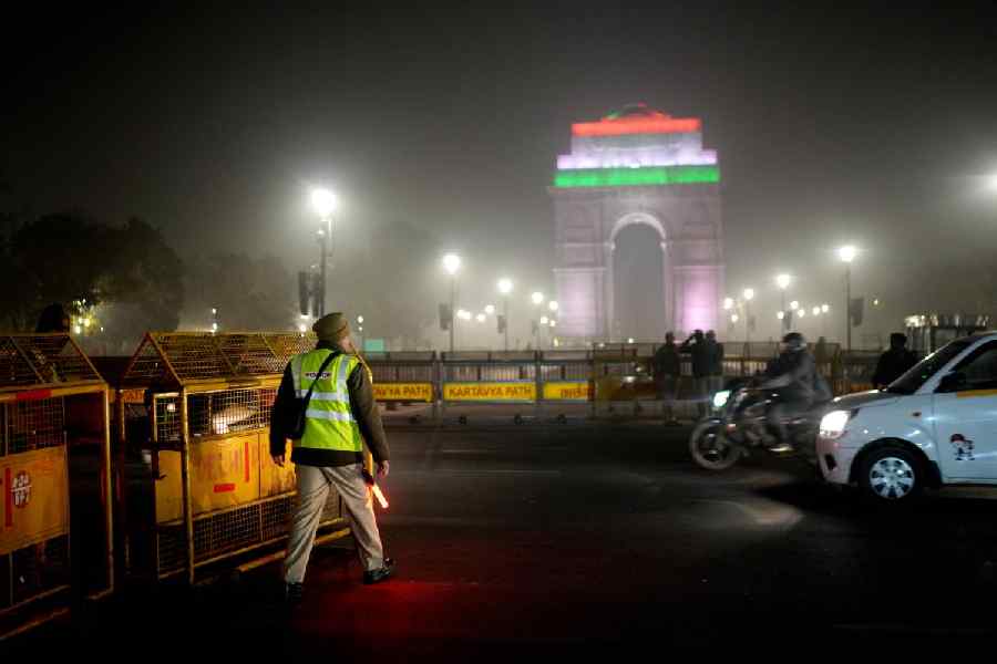 A police official stands guard on New Year’s on a cold winter evening, near the India Gate, in New Delhi, Wednesday, Dec. 31, 2025.