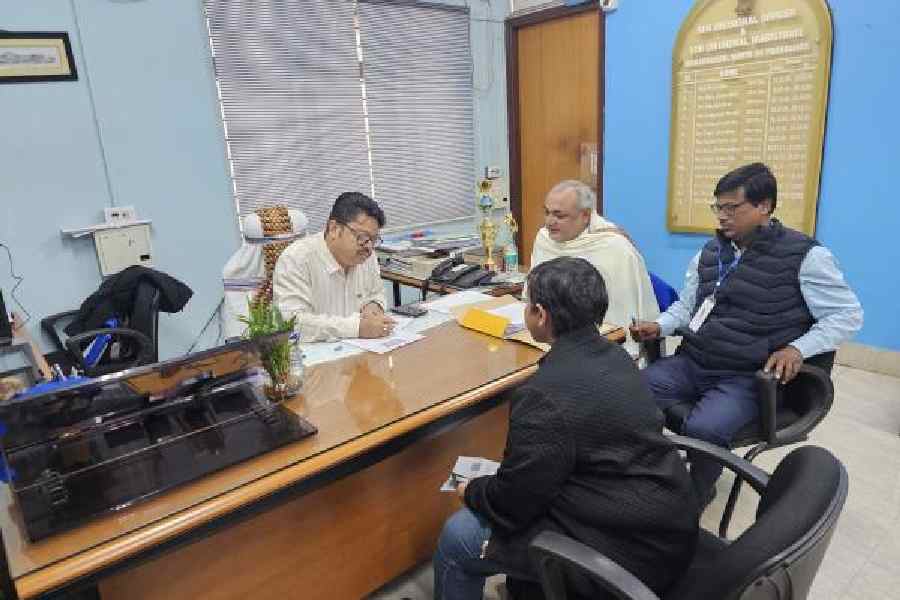 SIR hearing being undertaken at the sub-divisional office by SDO and electoral registration officer Suman Poddar while district roll observer Randhir Kumar (in shawl) and micro observer Subhasish Naskar look on. Residents of CJ Block, under Part 179, were appearing for the hearing. A total of 85 hearings took place at the venue on Monday. (Sudeshna Banerjee)