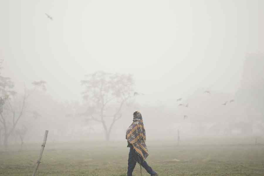 A man strolls amid low visibility on a foggy winter day, in New Delhi, Tuesday, Dec. 30, 2025.