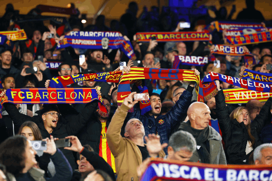 FC Barcelona fans hold scarves up in the stands.