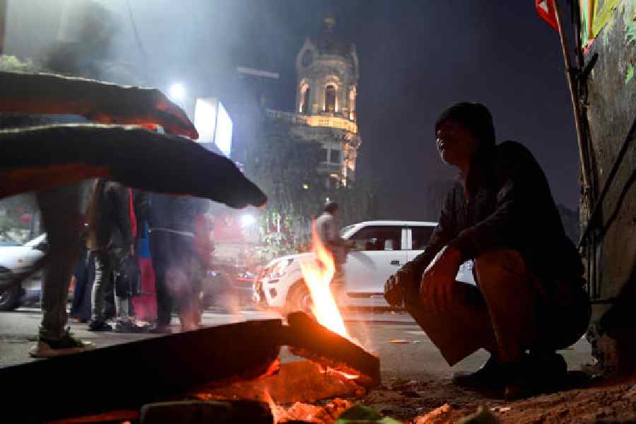 A man sits by a small fire to warm himself in Esplanade. Picture by Sanat Kr Sinha
