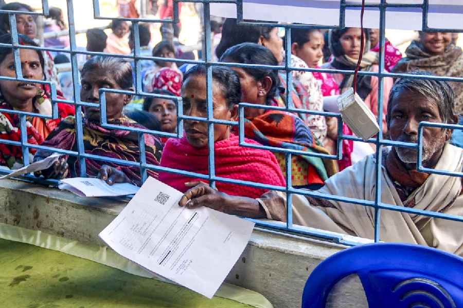 People wait in a queue at an SIR hearing centre in Balurghat, South Dinajpur, on Friday.