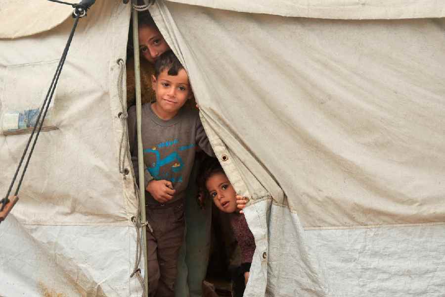 Displaced Palestinians shelter in a tent camp on a rainy day in Khan Younis