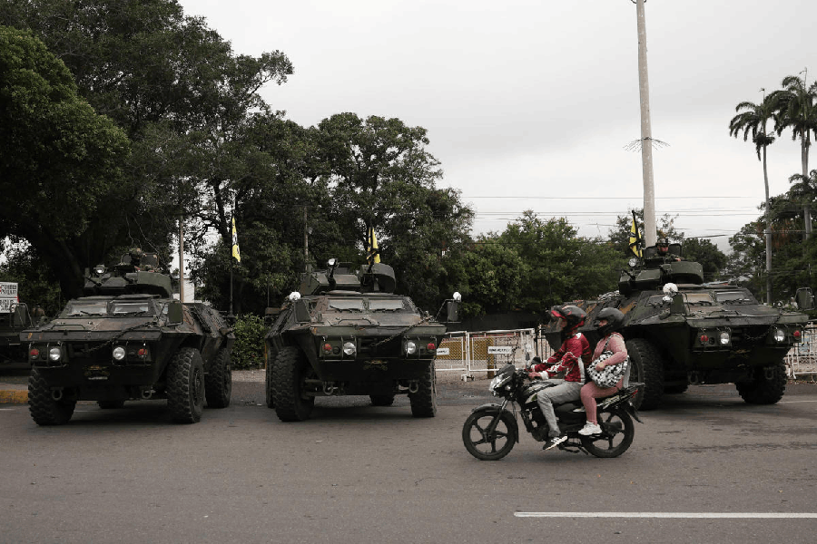 People ride a motorbike next to military vehicles as Colombian soldiers patrol the border between Venezuela and Colombia, after U.S. President Donald Trump said the U.S. has struck Venezuela and captured its President Nicolas Maduro, in Cucuta, Colombia, January 3, 2026.