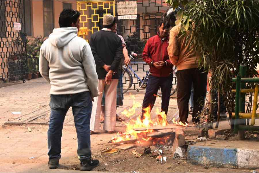 A group of people huddle around a fire on Theatre Road in Calcutta on Sunday. Picture by Bishwarup Dutta