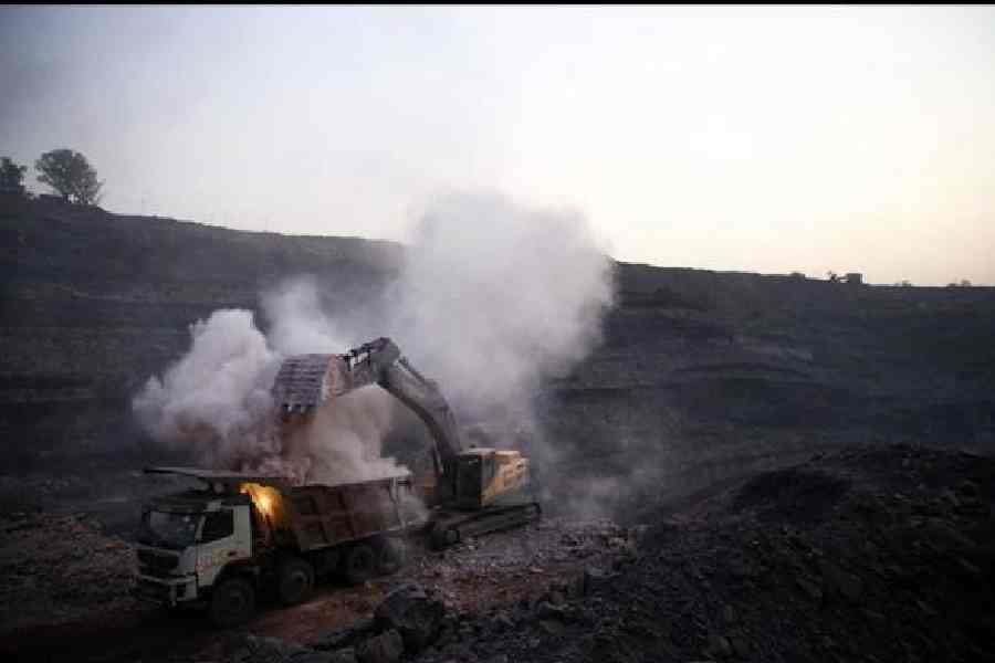 Dust clouds form as coal is loaded onto a truck at the Talcher coalfields