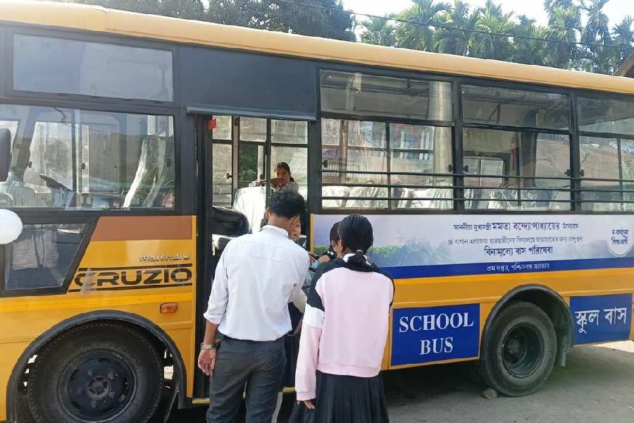 Students board a school bus that was introduced by the state labour department at Totopara in the Madarihat block of Alipurduar district on Monday.