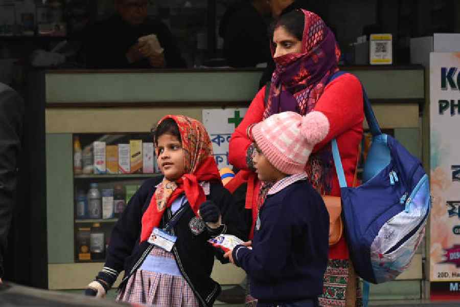 Schoolchildren wait for transport on Sarat Bose Road around noon on Tuesday. Picture by Bishwarup Dutta