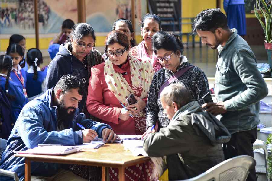 Booth Level Officers (BLOs) collect enumeration forms from voters during the ongoing Special Intensive Revision (SIR) of electoral rolls, in Prayagraj, Monday, Dec. 08, 2025.