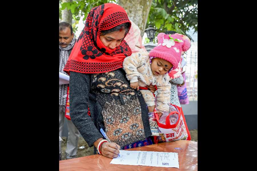 A woman fills a form as part of the SIR process in Nadia on Tuesday.