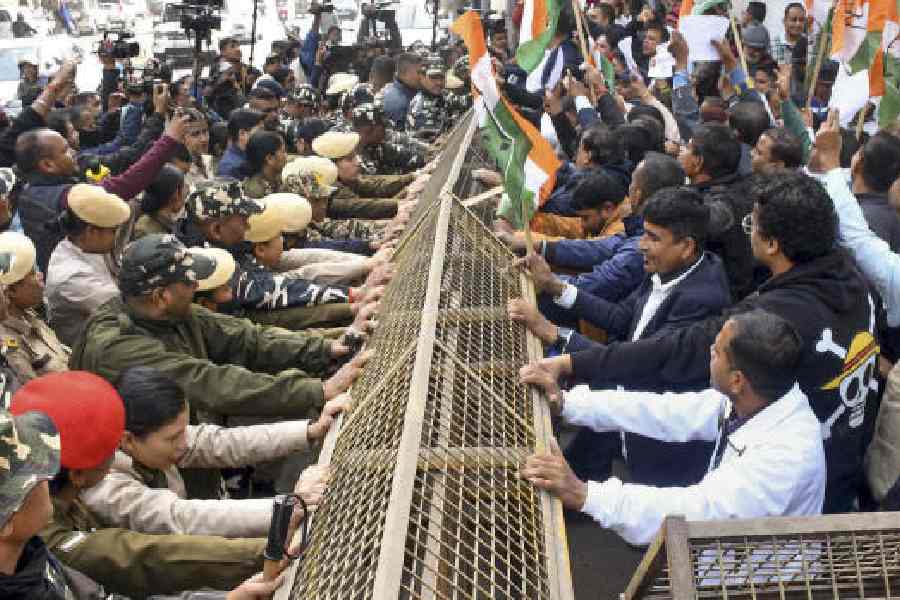 Security personnel try to stop protesters during an agitation by Assam Pradesh Congress Committee in Guwahati on Tuesday. 